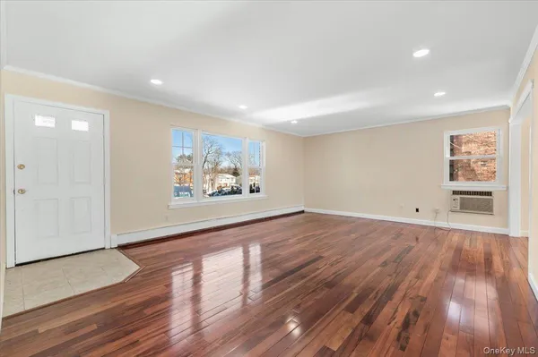 a view of a big room with wooden floor and windows
