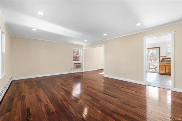 an empty room with wooden floor and natural light