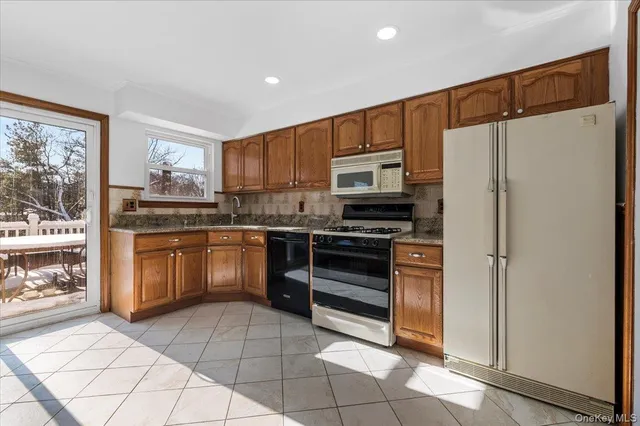 a kitchen with a refrigerator a stove top oven a sink and cabinets