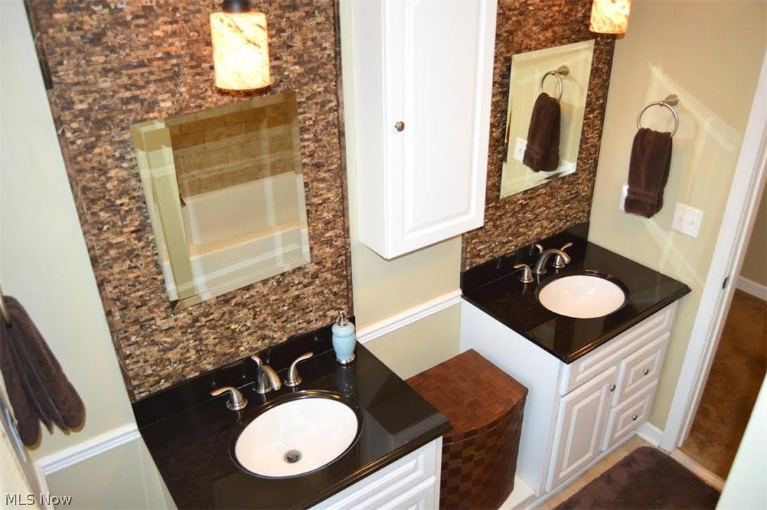 1251 Shields Road Youngstown, OH 44511 - Photo 11 of 24 So many upgrades in the Main Bath! Dual Vanities with Granite Countertops, Stone Backsplash, Tile Floor and Mirrored Medicine Cabinets.