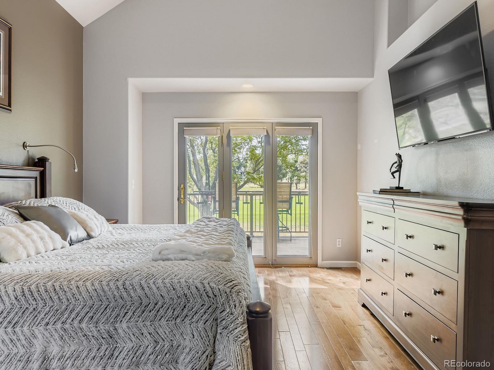 15906 Double Eagle Drive Morrison, CO 80465 - Photo 14 of 34 a bedroom with a bed and a flat tv screen on dresser