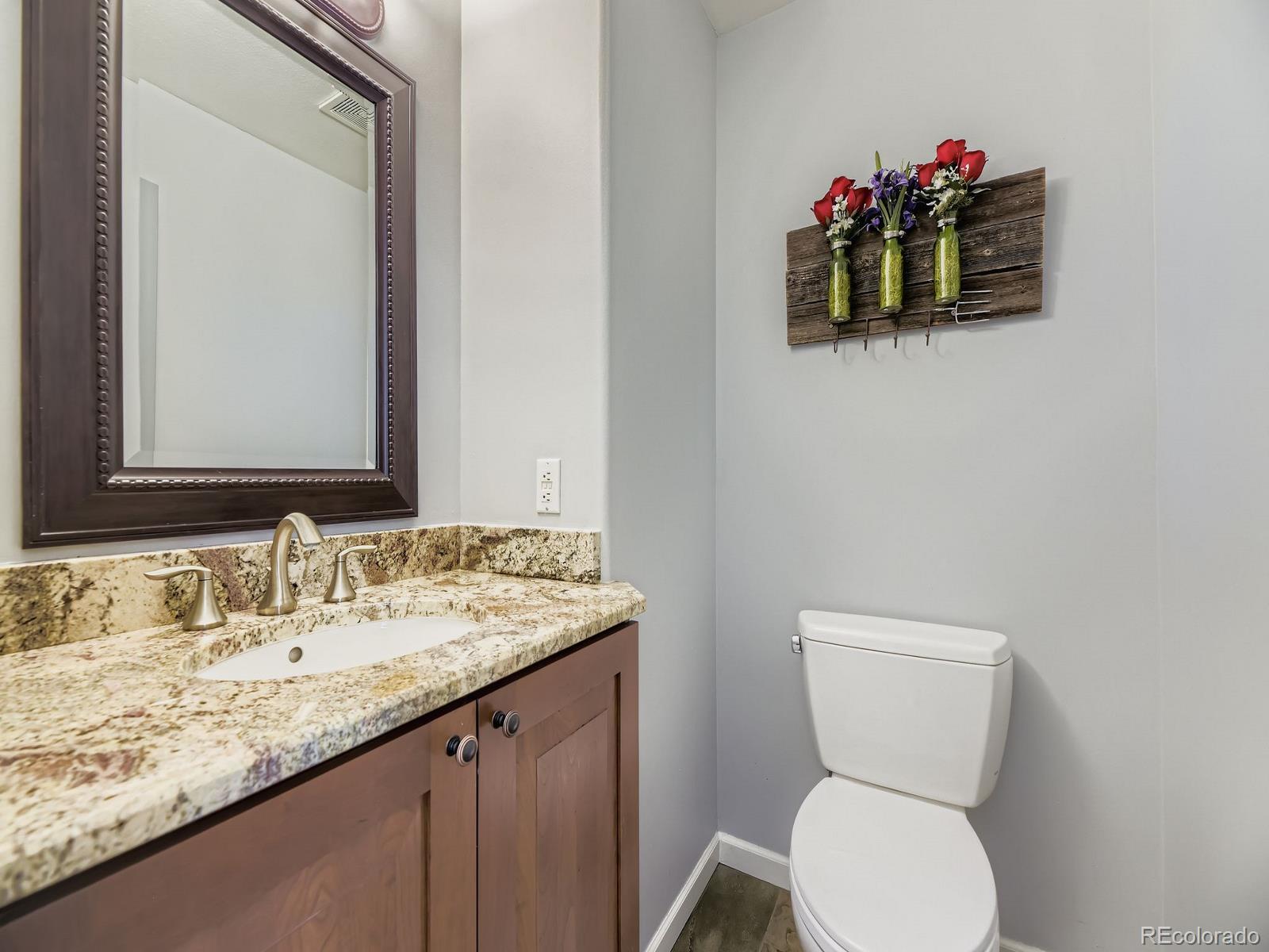 15906 Double Eagle Drive Morrison, CO 80465 - Photo 18 of 34 a bathroom with a toilet sink vanity and mirror