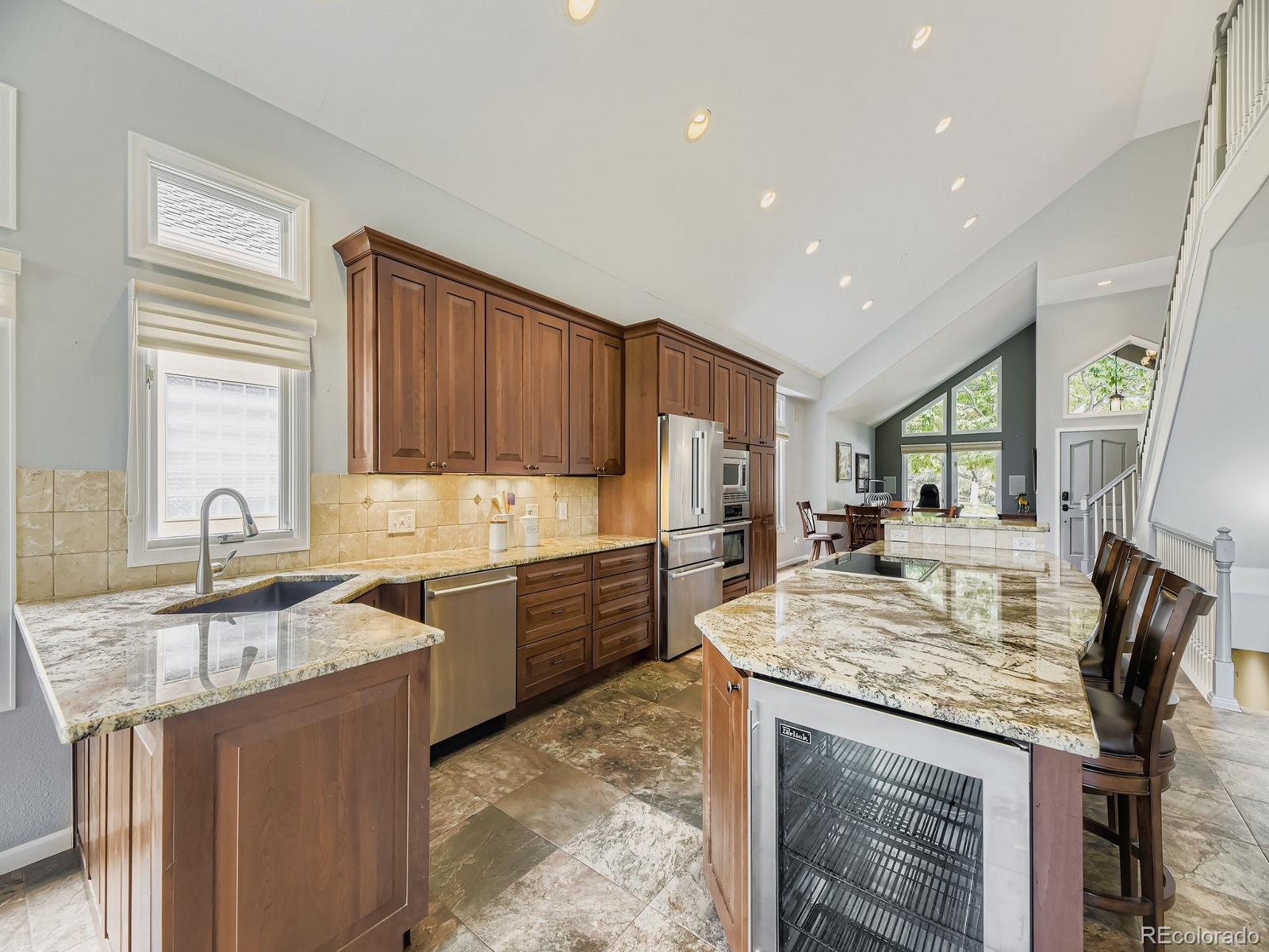 15906 Double Eagle Drive Morrison, CO 80465 - Photo 8 of 34 a kitchen with kitchen island granite countertop a sink stove and cabinets