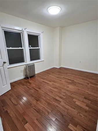 a view of empty room with wooden floor and front door