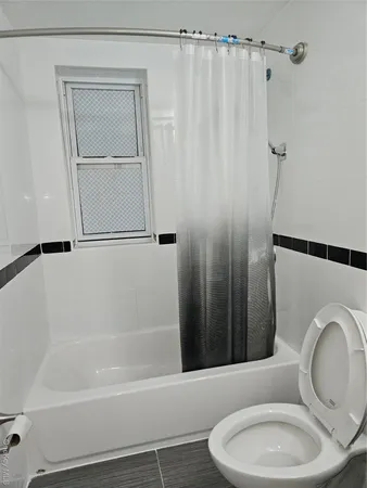 a view of empty room with wooden floor and window