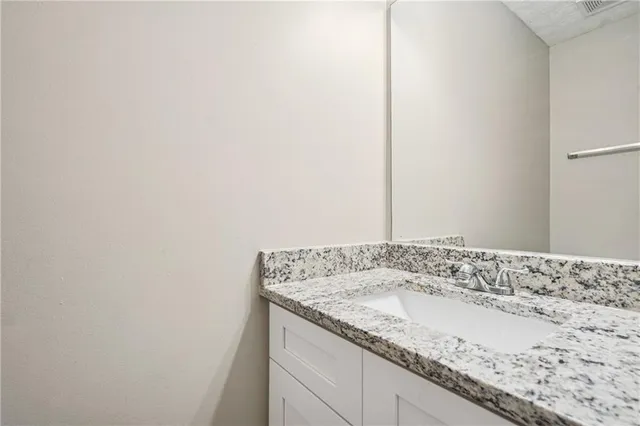 a bathroom with a granite countertop sink and vanity