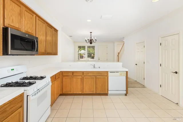 a large kitchen with granite countertop a stove a sink and a microwave