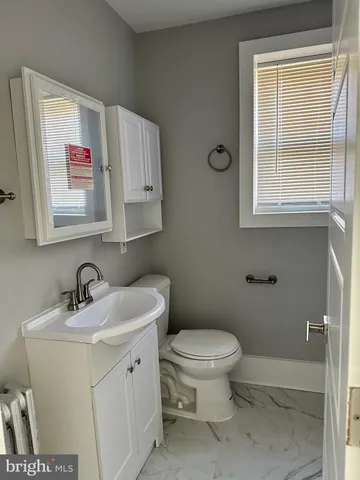 a bathroom with a toilet sink and mirror
