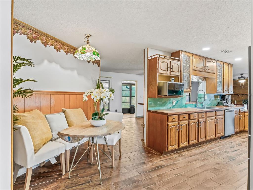 6350 Northeast 86th Avenue Bronson, FL 32621 - Photo 18 of 92 a view of a dining room with furniture a chandelier and wooden floor