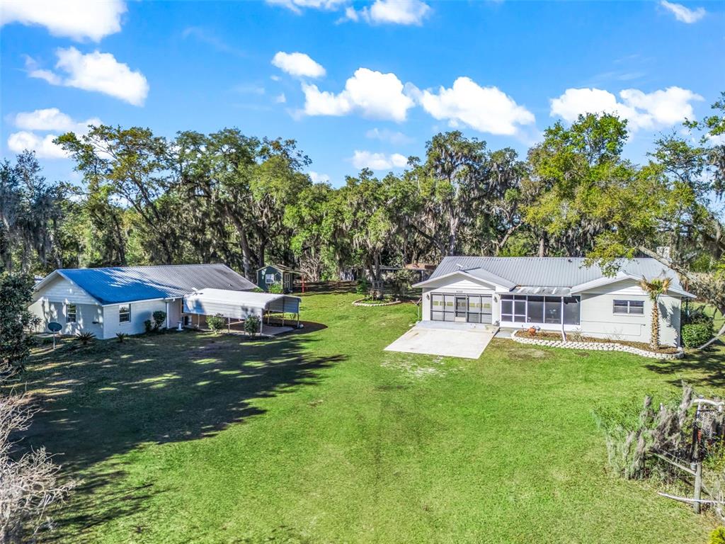 6350 Northeast 86th Avenue Bronson, FL 32621 - Photo 2 of 92 a front view of a house with a garden and trees