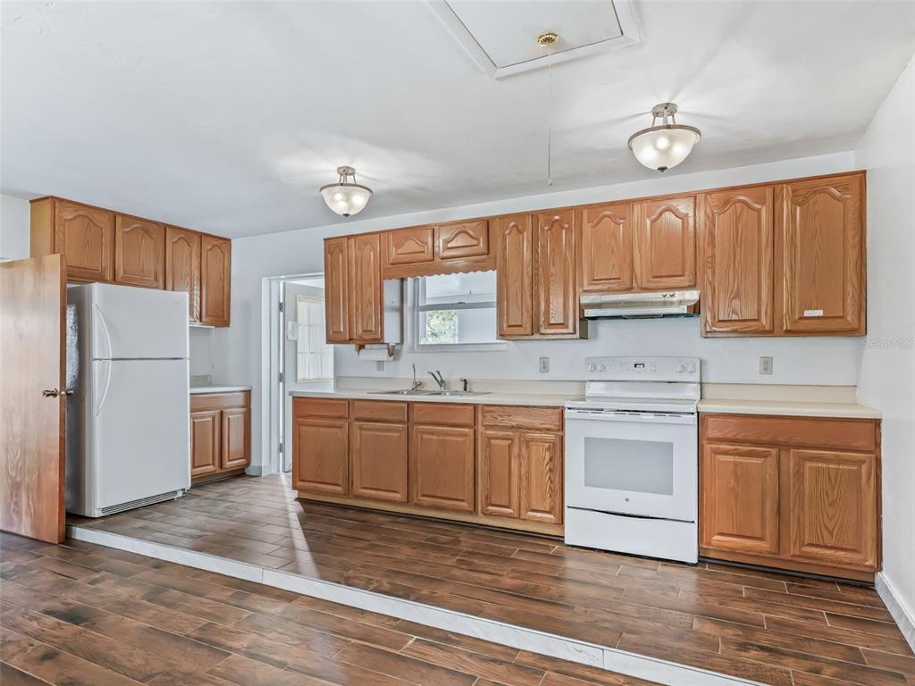 6350 Northeast 86th Avenue Bronson, FL 32621 - Photo 52 of 92 a kitchen with granite countertop a refrigerator and cabinets
