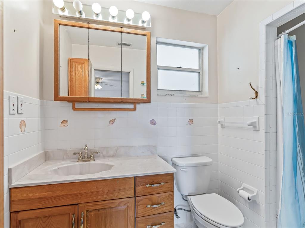 6350 Northeast 86th Avenue Bronson, FL 32621 - Photo 57 of 92 a bathroom with a granite countertop toilet a sink and mirror