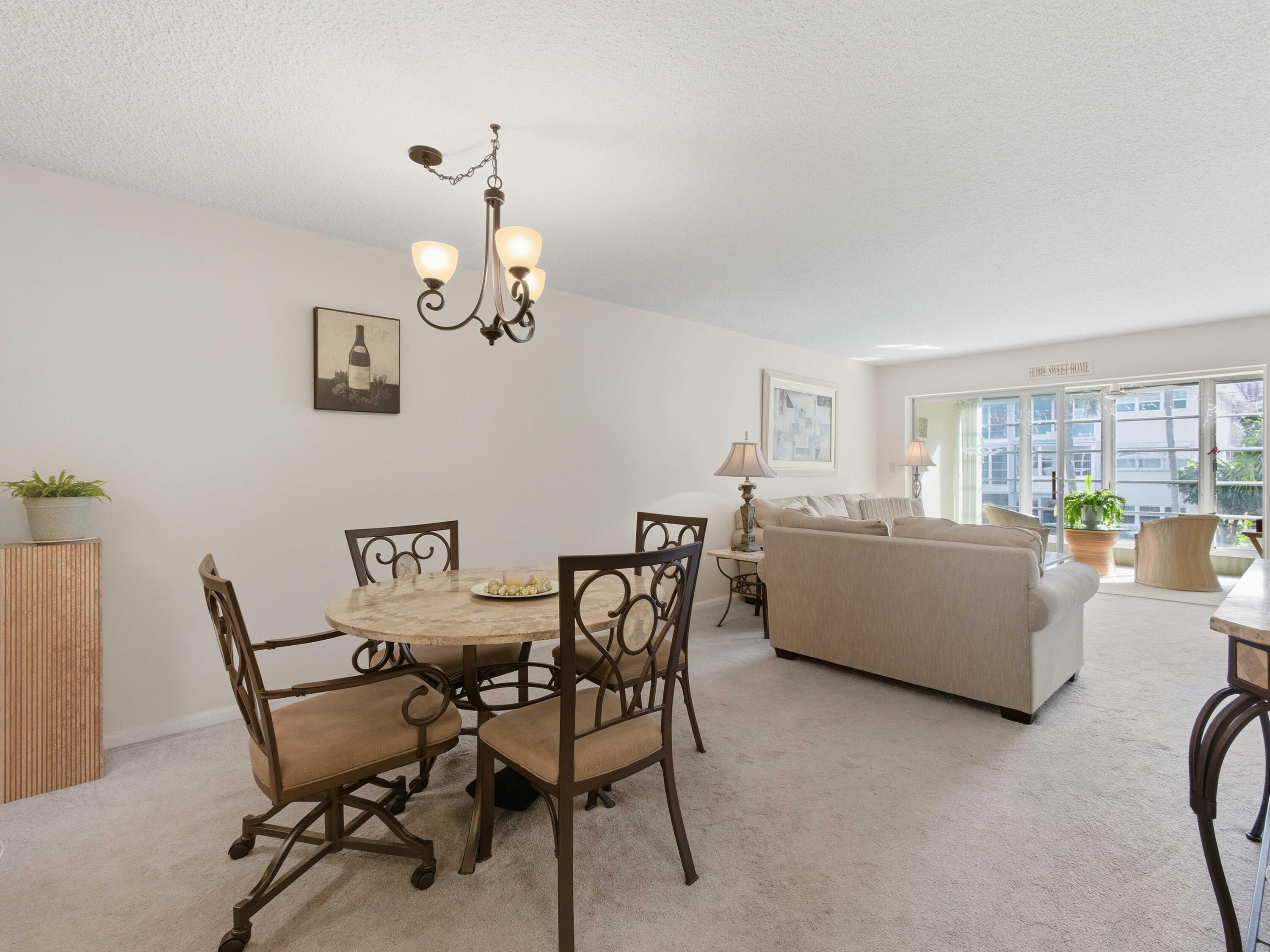 400 Northeast 20th Street, Unit A216 Boca Raton, FL 33431 - Photo 17 of 33 a dining room with furniture and a chandelier
