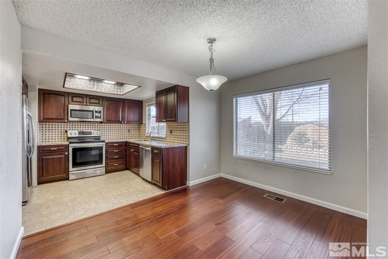 2741 Pajaro Place Reno, NV 89502 - Photo 11 of 36 a open kitchen with stainless steel appliances granite countertop a stove top oven a sink dishwasher a refrigerator and a fireplace with wooden floor
