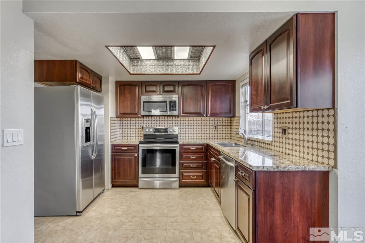 2741 Pajaro Place Reno, NV 89502 - Photo 12 of 36 a kitchen with stainless steel appliances granite countertop a stove sink and refrigerator