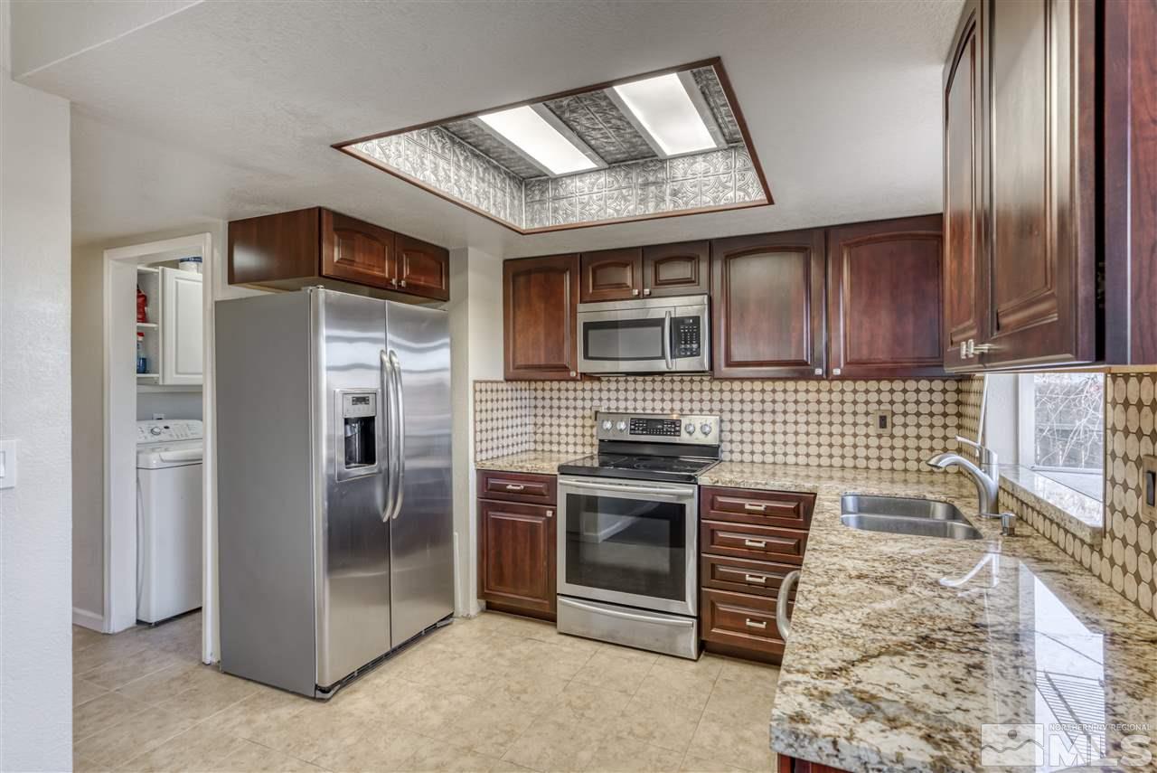 2741 Pajaro Place Reno, NV 89502 - Photo 13 of 36 a kitchen with stainless steel appliances granite countertop a stove a refrigerator and a sink