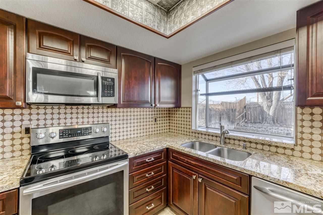 2741 Pajaro Place Reno, NV 89502 - Photo 15 of 36 a kitchen with granite countertop a stove sink and microwave