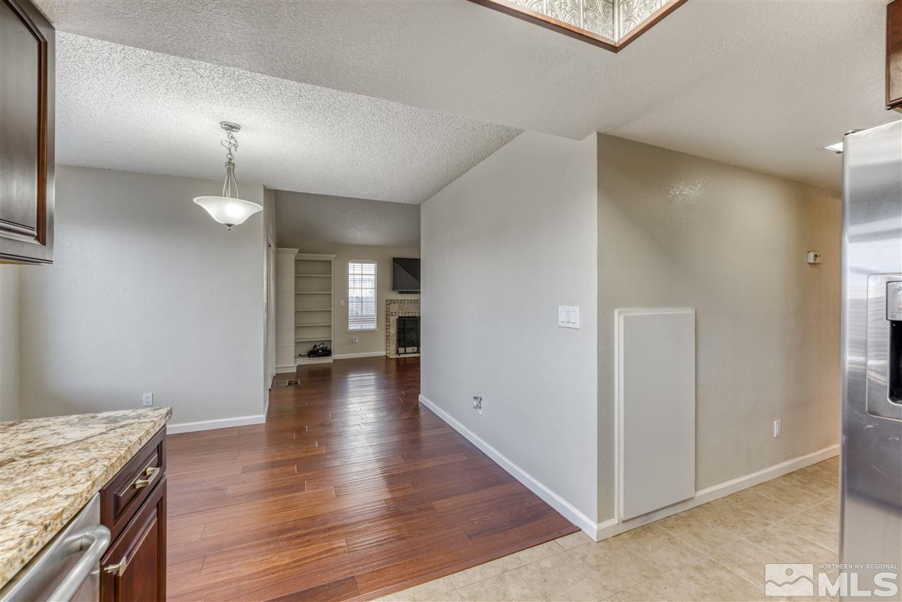 2741 Pajaro Place Reno, NV 89502 - Photo 16 of 36 a view of a kitchen and an empty room with wooden floor