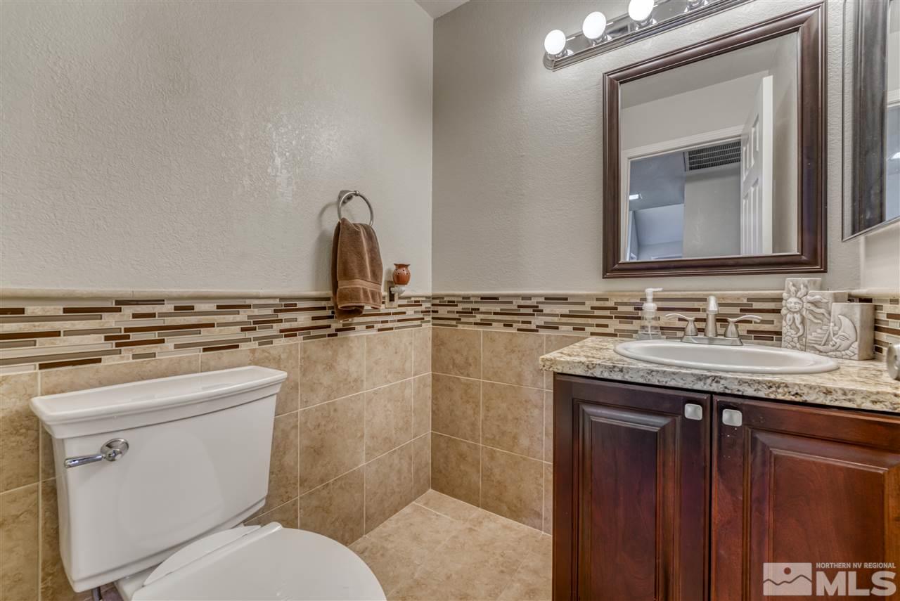 2741 Pajaro Place Reno, NV 89502 - Photo 17 of 36 a bathroom with a granite countertop sink a toilet and a mirror