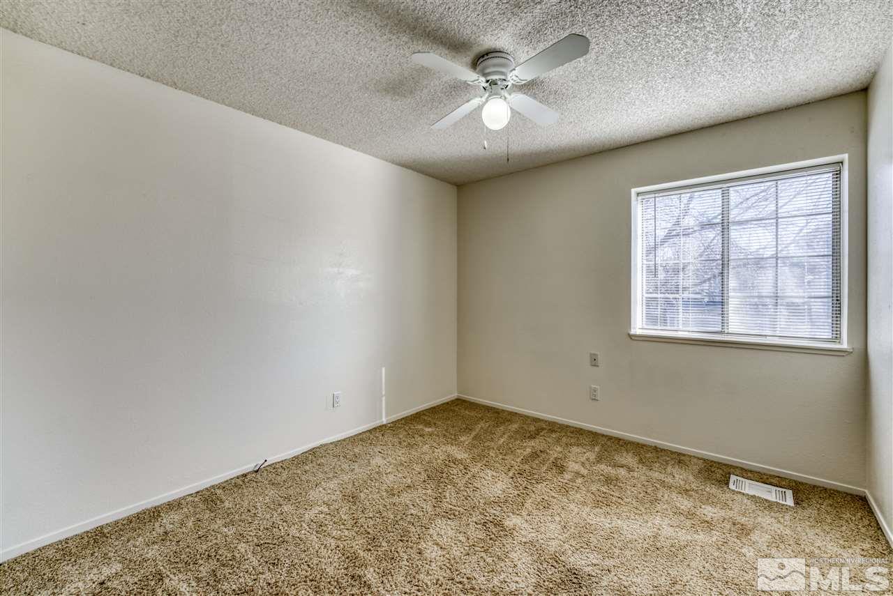 2741 Pajaro Place Reno, NV 89502 - Photo 22 of 36 an empty room with a chandelier fan and windows