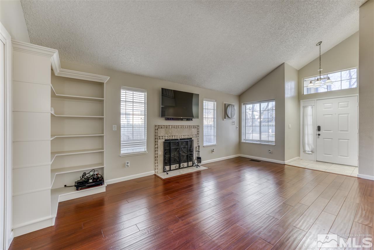 2741 Pajaro Place Reno, NV 89502 - Photo 8 of 36 a view of a livingroom with wooden floor a fireplace and windows