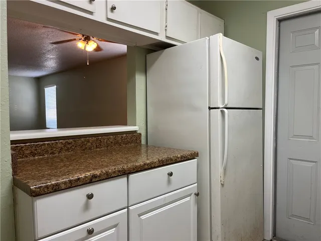 a bathroom with a granite countertop sink and refrigerator