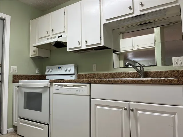 a kitchen with cabinets appliances and a sink