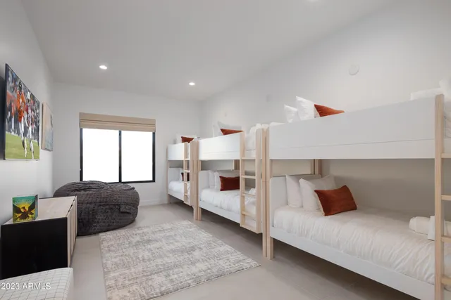 a large bed sitting in a bedroom next to a lamp