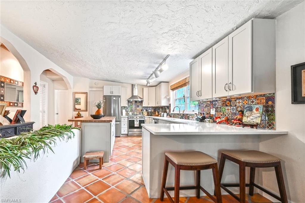 3113 Basin Street Naples, FL 34112 - Photo 23 of 49 a kitchen with a dining table chairs and sink