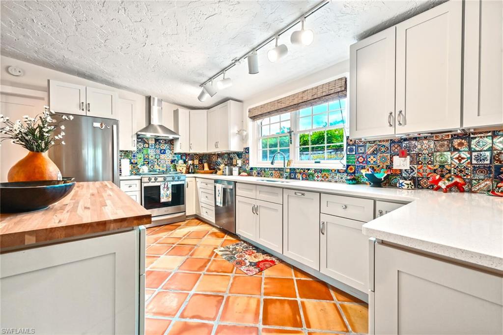 3113 Basin Street Naples, FL 34112 - Photo 25 of 49 a kitchen with stainless steel appliances kitchen island granite countertop a refrigerator sink and cabinets