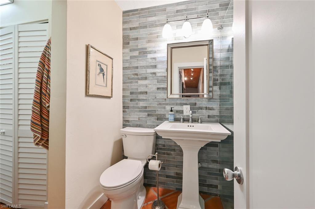 3113 Basin Street Naples, FL 34112 - Photo 26 of 49 a bathroom with a toilet sink and mirror