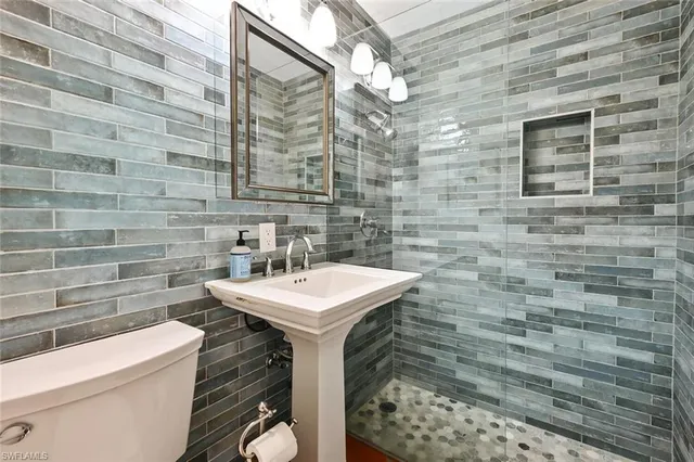 a bathroom with a sink a toilet and mirror