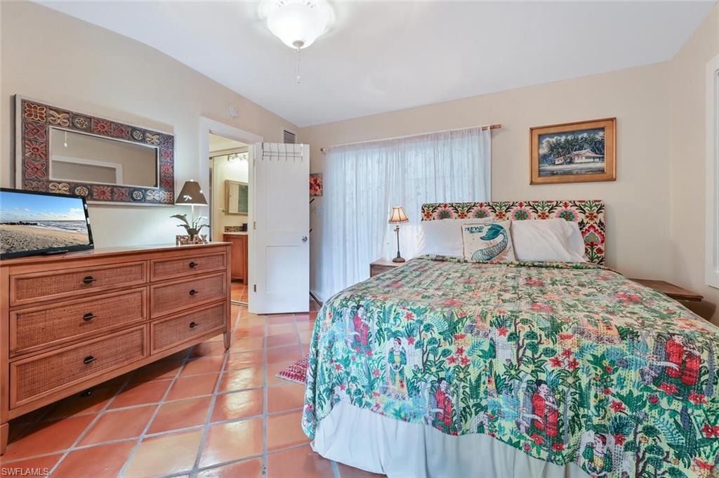 3113 Basin Street Naples, FL 34112 - Photo 36 of 49 a bedroom with a bed and a dresser in it