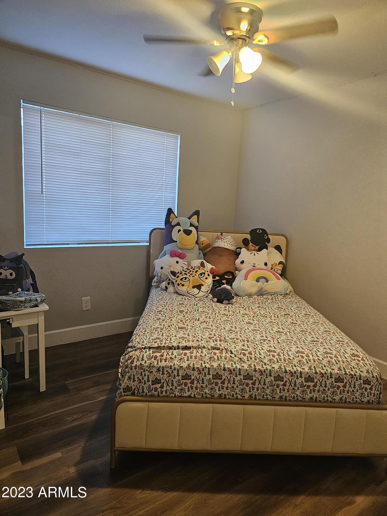 8738 West Granada Road Phoenix, AZ 85037 - Photo 8 of 13 a bed sitting in a bedroom next to a window