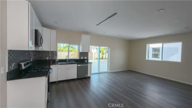 a kitchen with granite countertop a stove top oven sink and cabinets