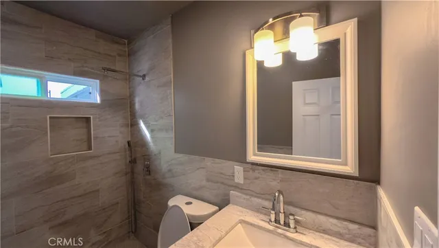a bathroom with a toilet sink and mirror