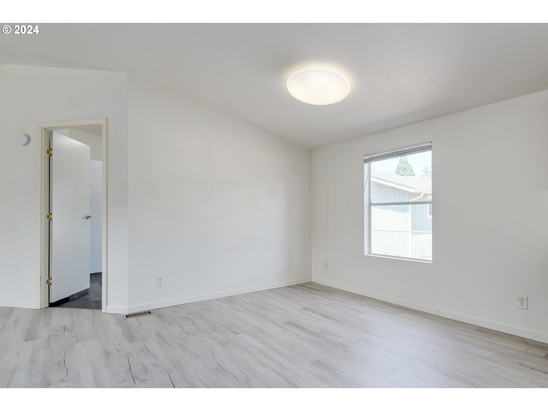 2893 Ava Street Eugene, OR 97404 - Photo 8 of 29 a view of an empty room with wooden floor and a window