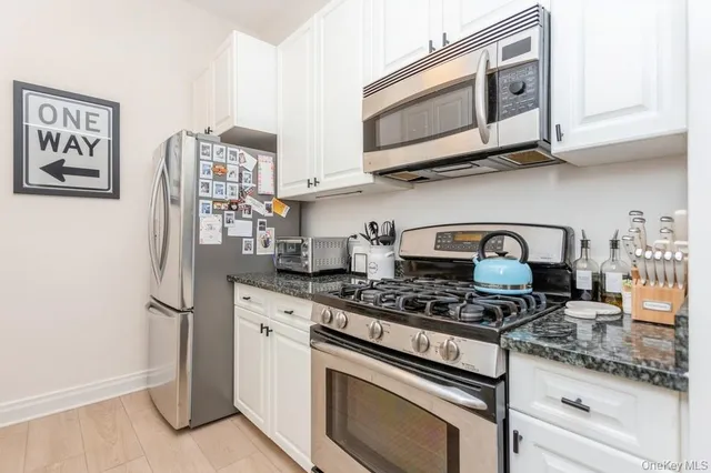a kitchen with stainless steel appliances granite countertop a stove and a refrigerator