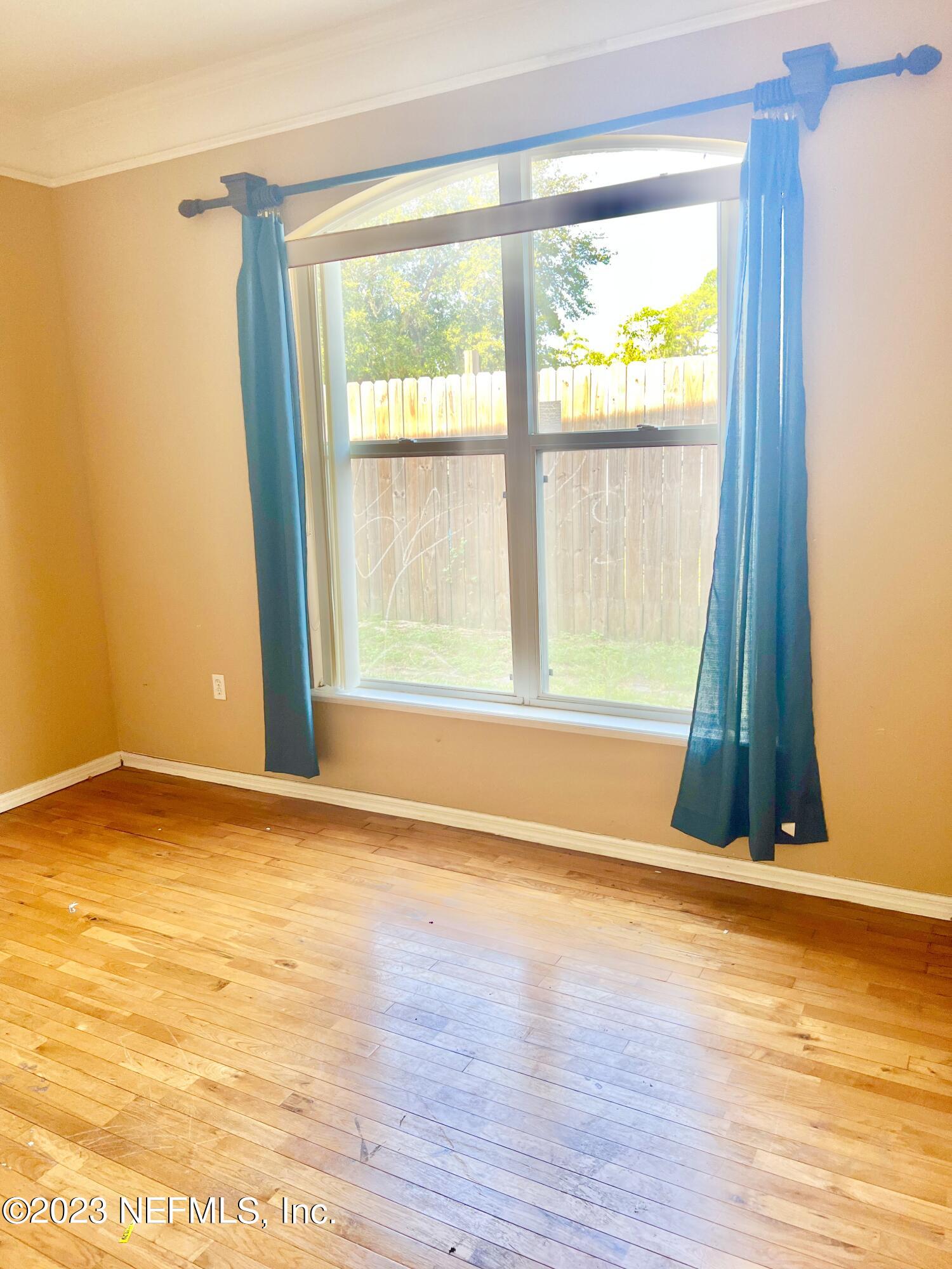 7388 Spring Hill Road Jacksonville, FL 32244 - Photo 6 of 28 a view of an empty room with wooden floor and a window