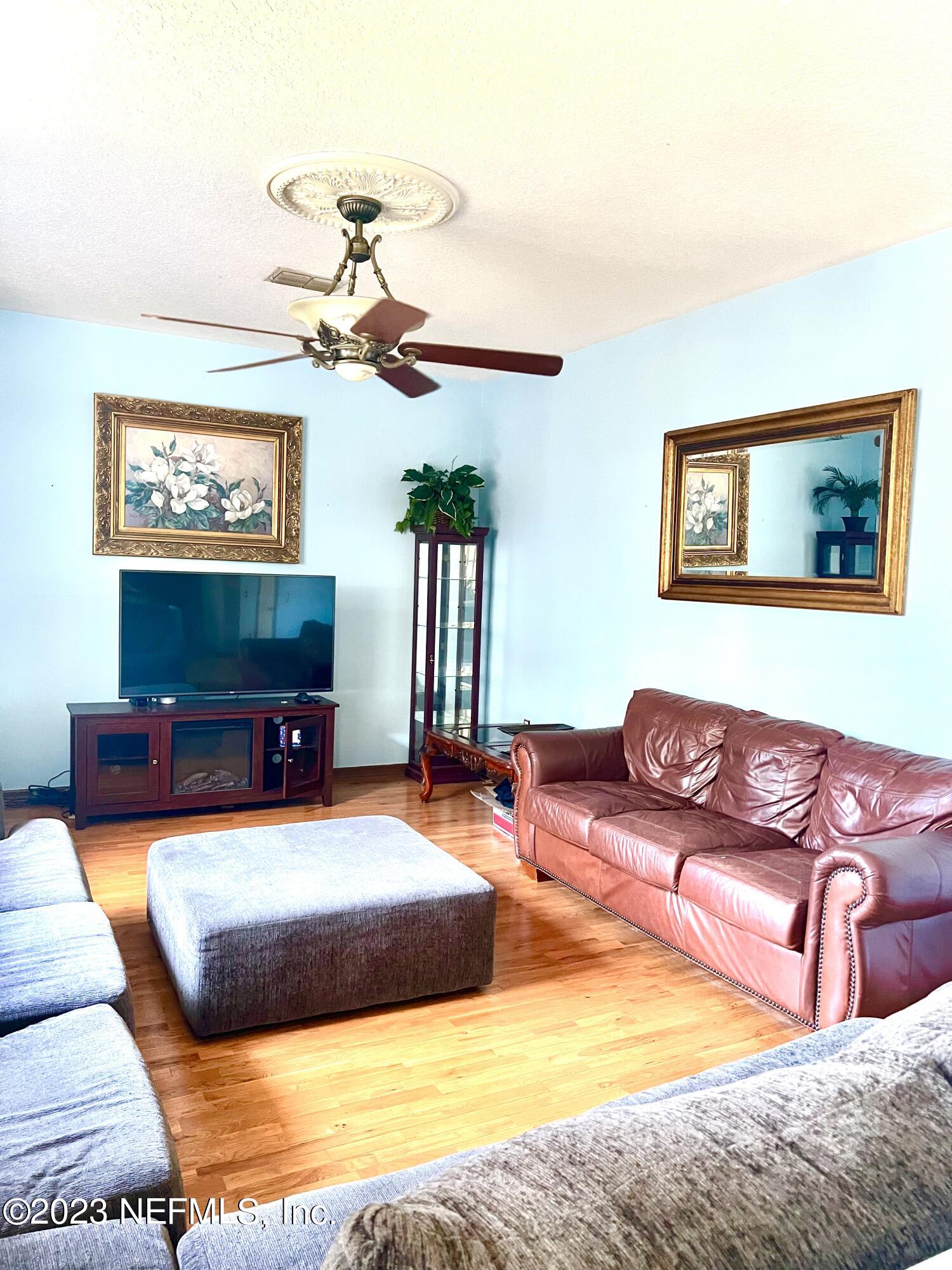 7388 Spring Hill Road Jacksonville, FL 32244 - Photo 7 of 28 a living room with furniture and a flat screen tv