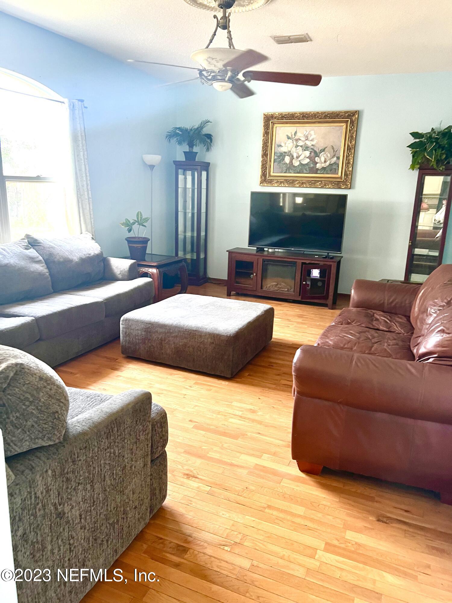 7388 Spring Hill Road Jacksonville, FL 32244 - Photo 8 of 28 a living room with furniture and a flat screen tv