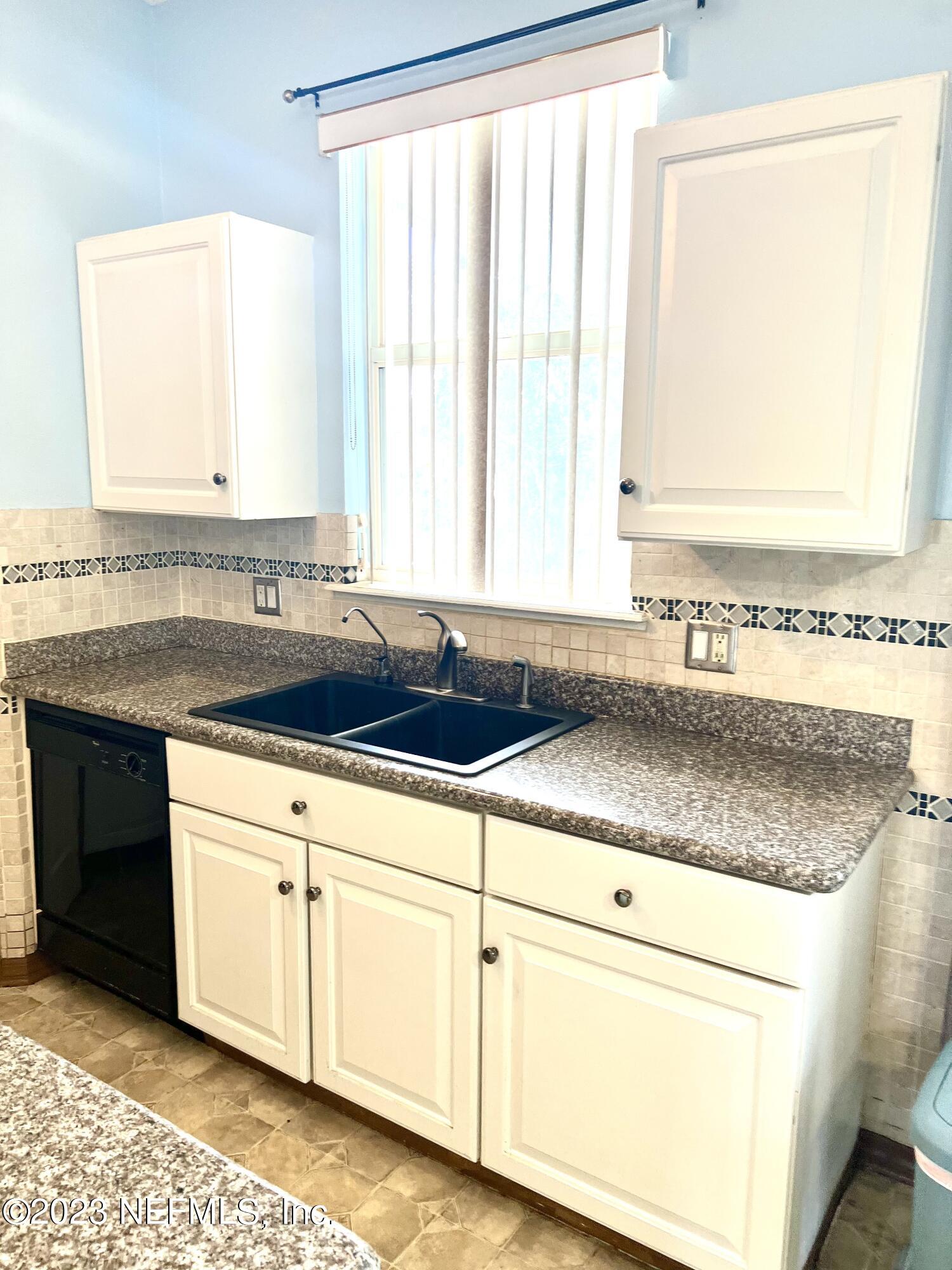 7388 Spring Hill Road Jacksonville, FL 32244 - Photo 9 of 28 a kitchen with granite countertop a sink and a white cabinets