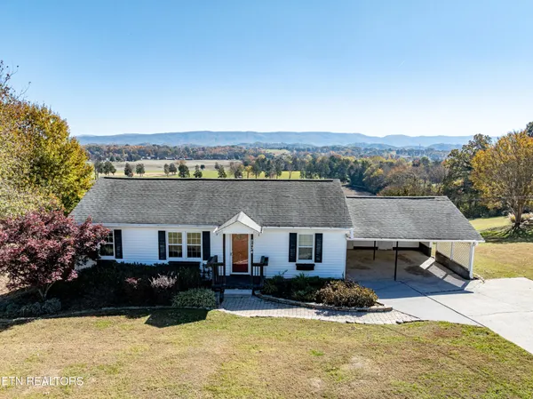 a aerial view of a house with a yard and large tree