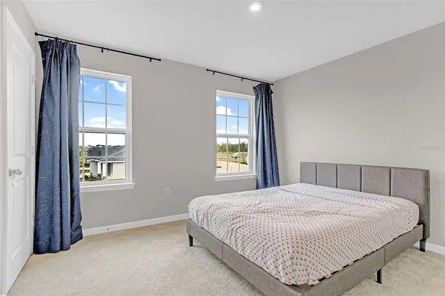 a bedroom with a bed next to a window