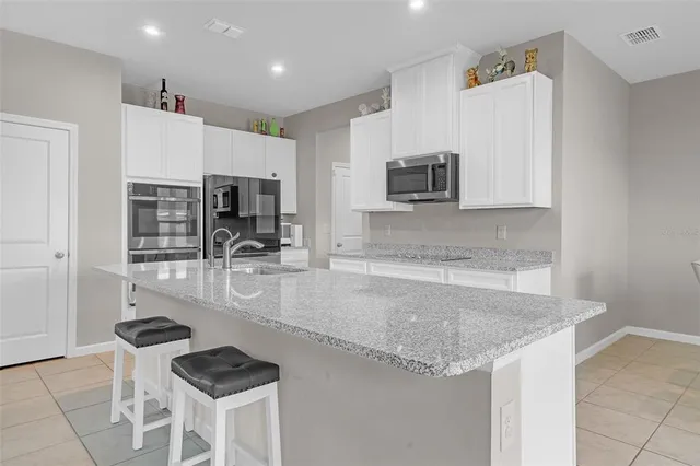 a kitchen with stainless steel appliances granite countertop a sink and a refrigerator