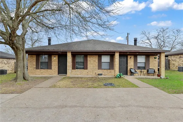 a front view of a brick building with a yard