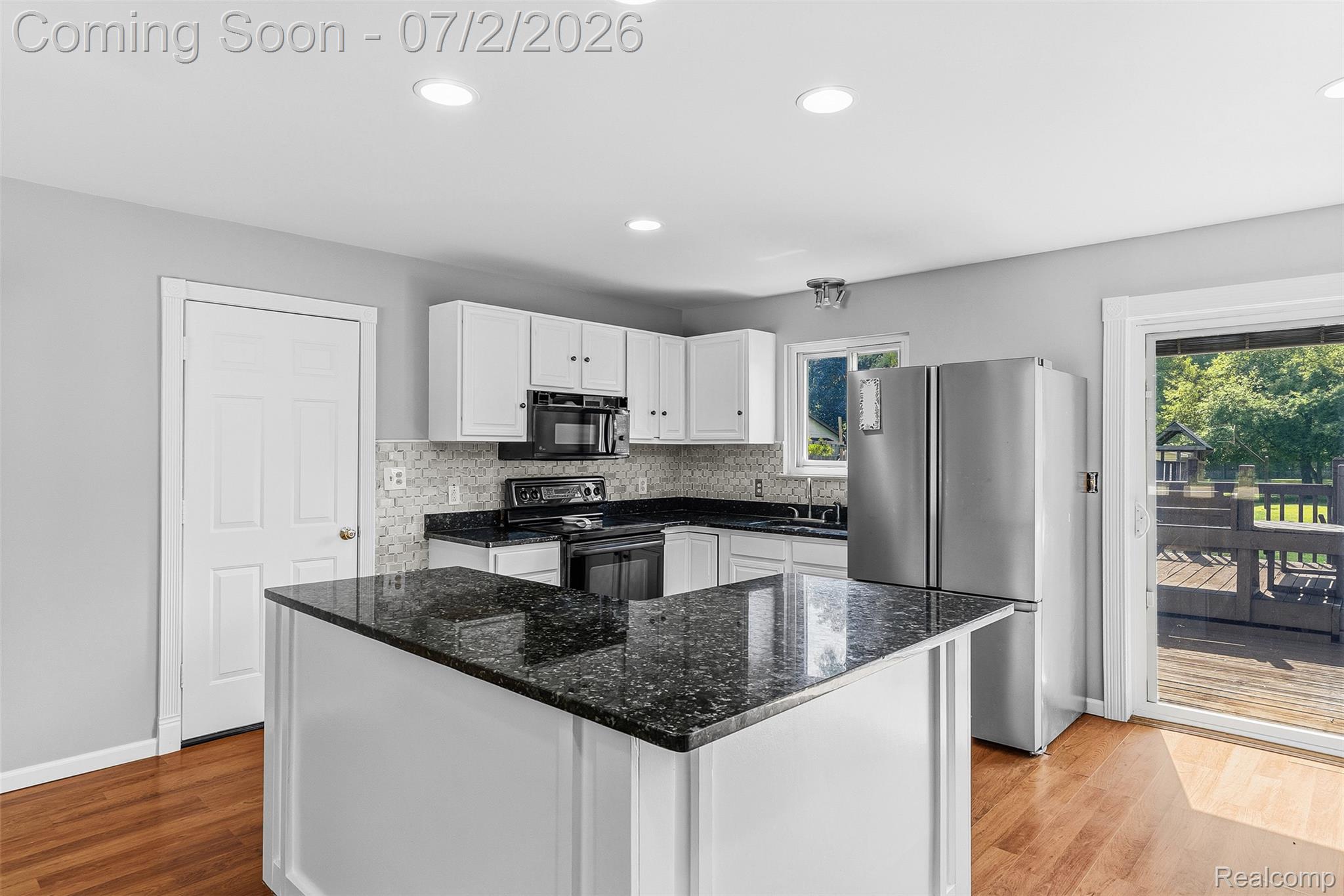 305 East Road Holly, MI 48442 - Photo 10 of 41 Kitchen featuring a central island with a dark countertop, white cabinetry, and stainless steel appliances