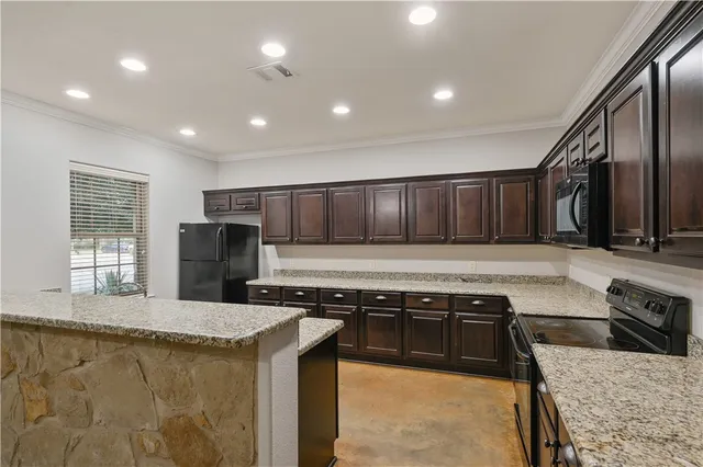 a kitchen with a stove sink and cabinets
