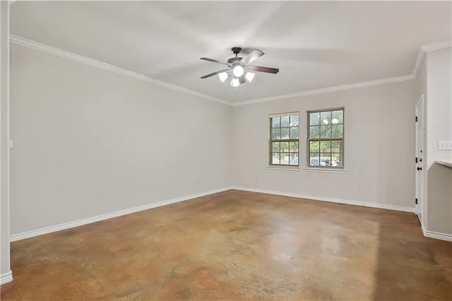 an empty room with windows and ceiling fan