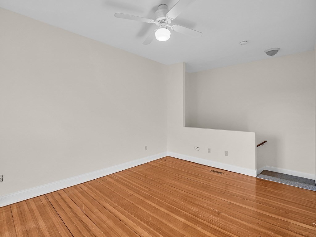 775 Bridge Street Lowell, MA 01850 - Photo 15 of 42 an empty room with wooden floor and fan